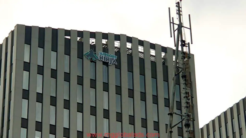 Support Ninja building with outdoor signage and vertical windows in Makati near telecom tower, by M&G Global Ads.