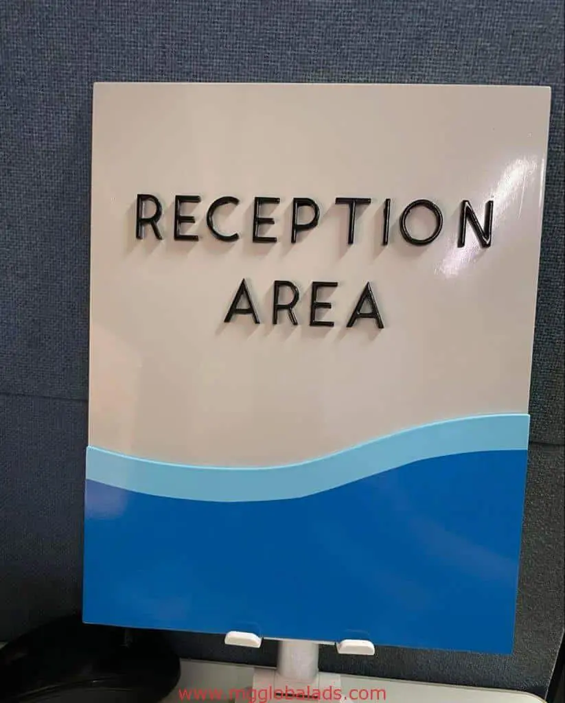 Acrylic reception area signage with black text and blue wave pattern, wall-mounted in Makati office by M&G Global Ads.