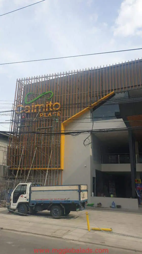 Santo Plaza pylon signage for commercial client in Quezon City, brown and yellow modern facade, white truck by M&G Global Ads.