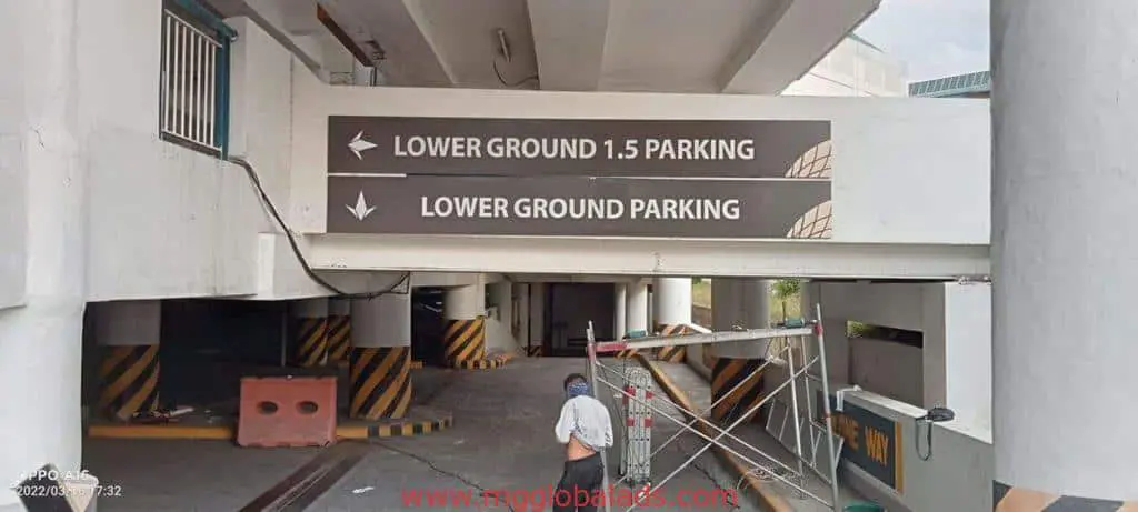 Indoor parking signage for Lower Ground 1.5 Parking in Makati, with construction materials nearby, by M&G Global Ads.