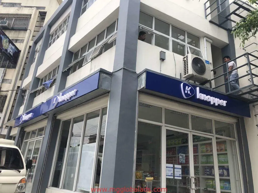 Knopper acrylic signage on a modern building in BGC, above large glass windows and outdoor staircase, by M&G Global Ads.