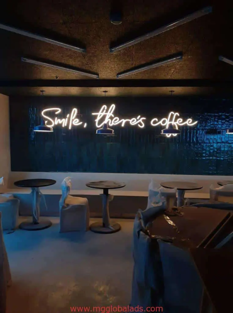 Metallic wall LED neon signage in a dimly lit café in Ortigas reads Smile, there’s coffee by M&G Global Ads.