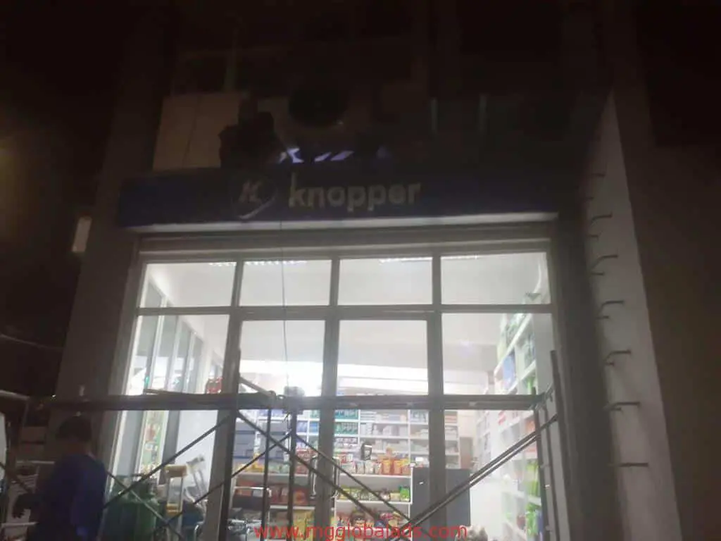 LED signage for Knopper shop with glass doors and product shelves in Makati, scaffolding and a person by entrance by M&G Global Ads.