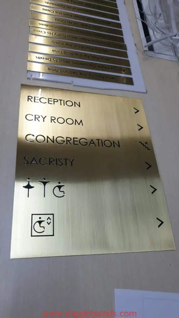 Wayfinding building brass engrave signage in Makati: gold metallic sign with black text, arrows, and icons by M&G Global Ads.