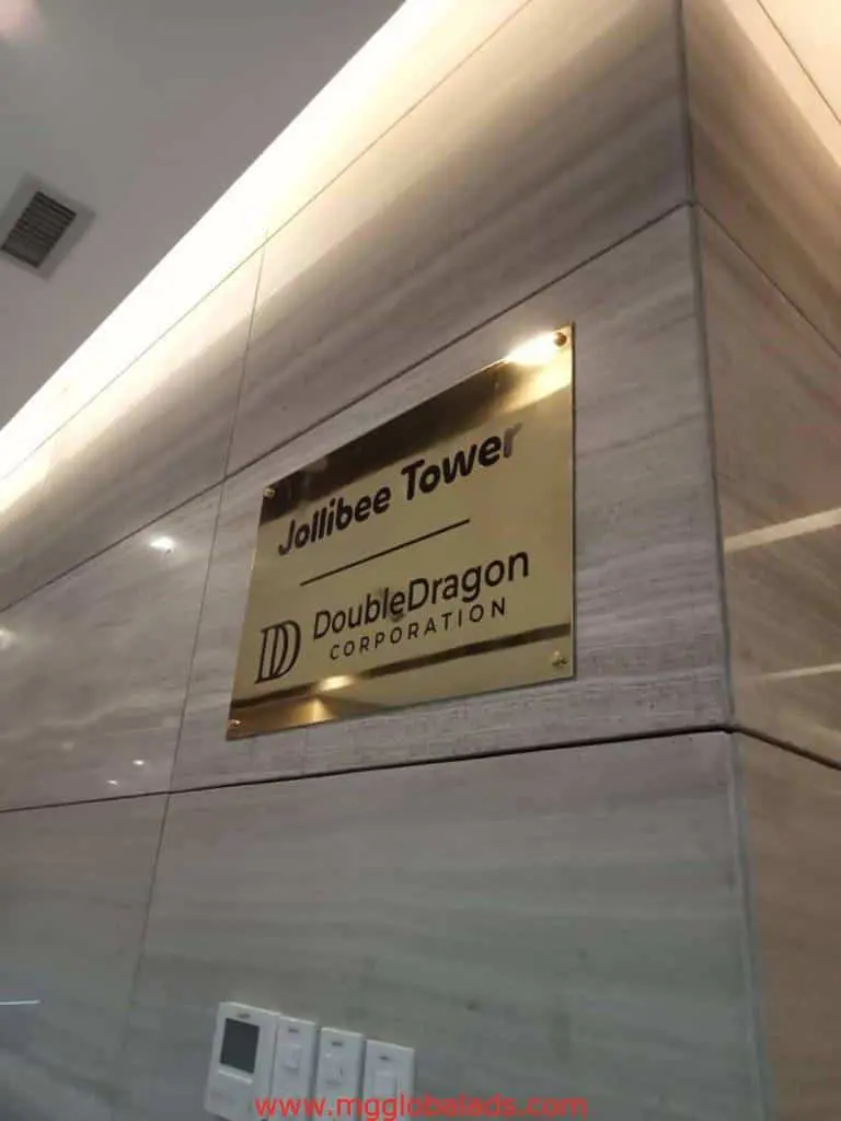 Jollibee Tower building brass engrave signage with DoubleDragon logo in Ortigas, four switches below it. By M&G Global Ads.