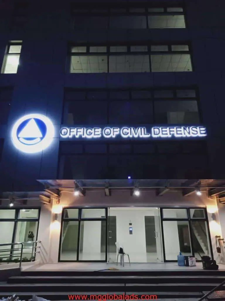 Illuminated outdoor office signage for Office of Civil Defense in Quezon City at night, glass door entrance—by M&G Global Ads.