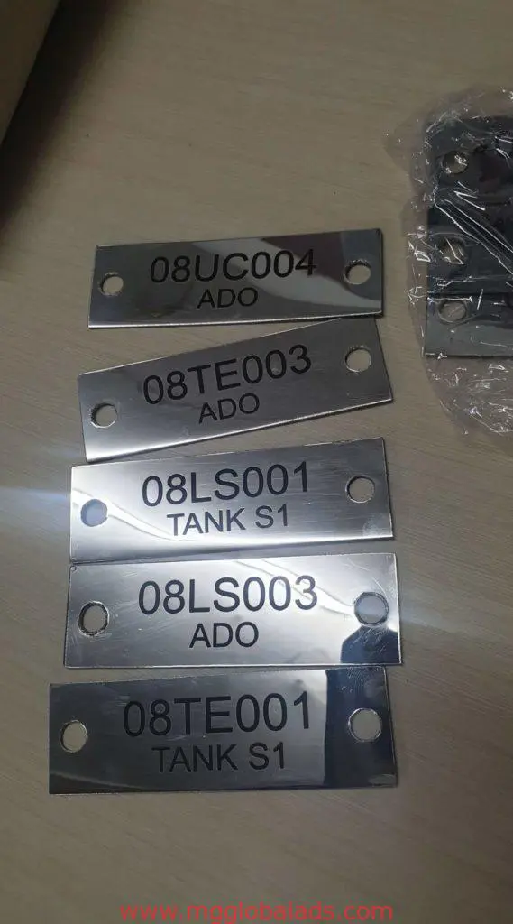 Metallic outdoor signage nameplates with codes and bolt holes, labeled TANK S1/ADO, in Makati by M&G Global Ads.