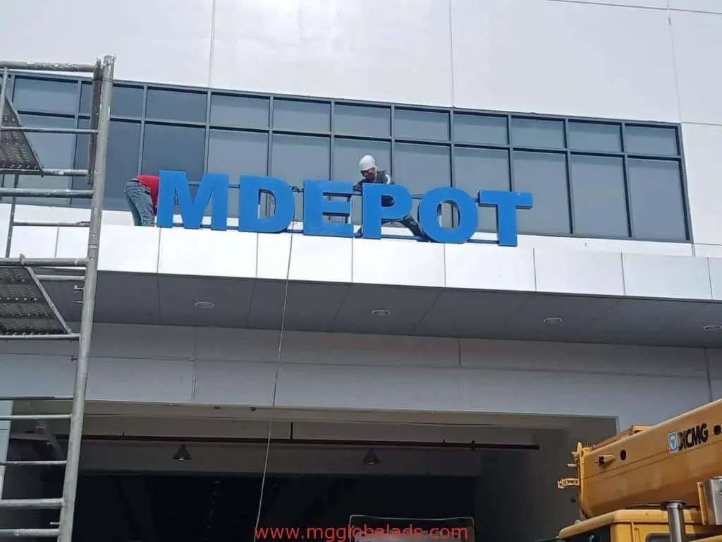 Building facade signage installation for MDEPOT in Quezon City using crane and scaffolding by M&G Global Ads.