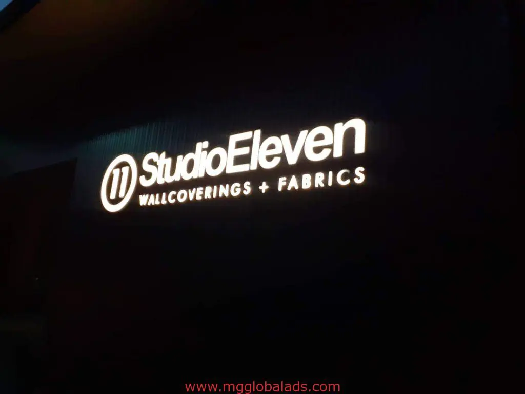Metallic building signage for Studio Eleven Wallcoverings + Fabrics with circular logo in Makati, illuminated at night by M&G Global Ads.