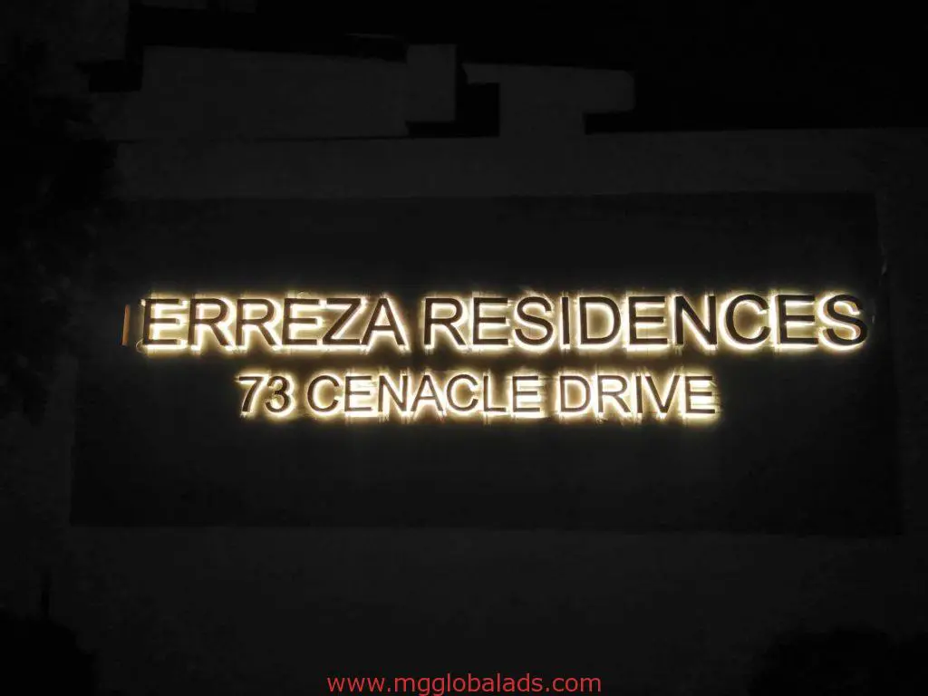 Illuminated metallic building signage for ERREZA RESIDENCES in San Juan at night, glowing letters by M&G Global Ads.