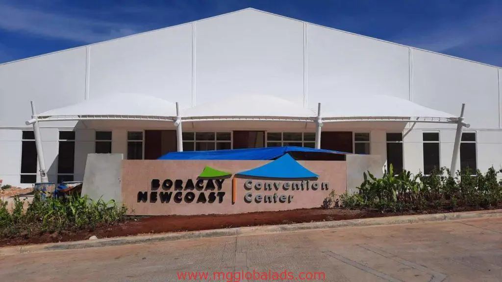 Outdoor convention center signage for Boracay Newcoast Convention Center, modern white facade, greenery, Makati by M&G Global Ads.
