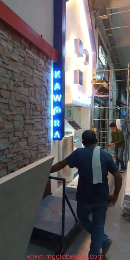 Blue neon LED signage installation for KAWPRA client inside a stone-walled Makati building under construction by M&G Global Ads.