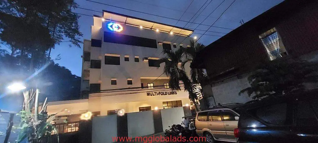 Illuminated acrylic signage for MG GLOBAL ADS on a modern building at dusk in Ortigas, by M&G Global Ads.