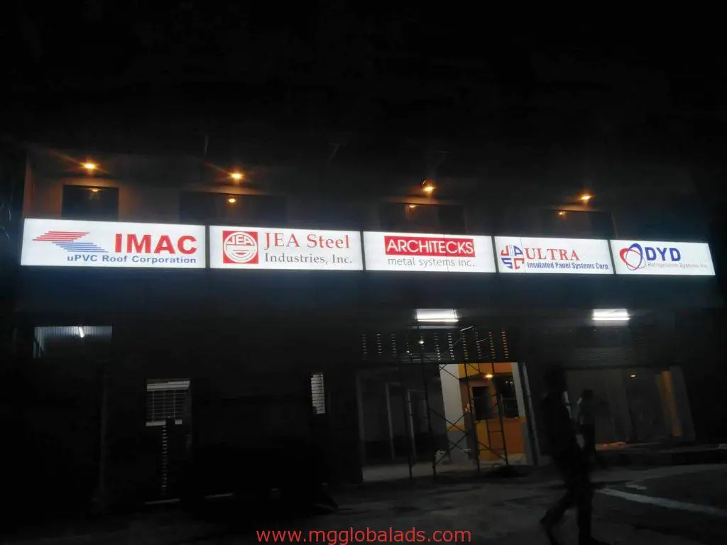 LED signage for IMAC, JEA Steel, ARCHITECKS, ULTRA, and DYD on a building in Ortigas at night by M&G Global Ads.