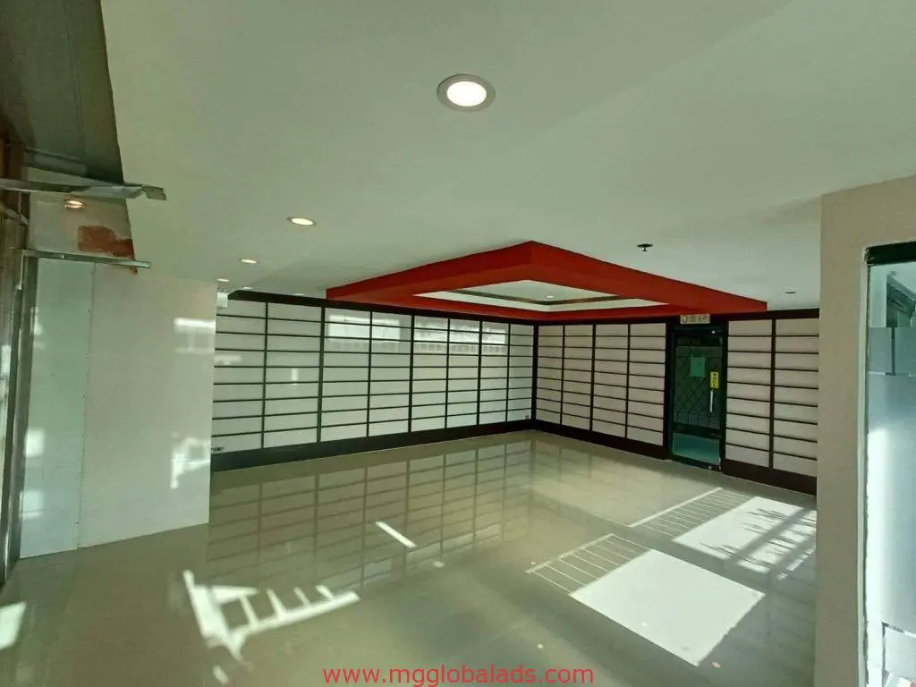 Acrylic indoor signage in a spacious Makati room with shoji panels, tiled floors, and red ceiling accent by M&G Global Ads.