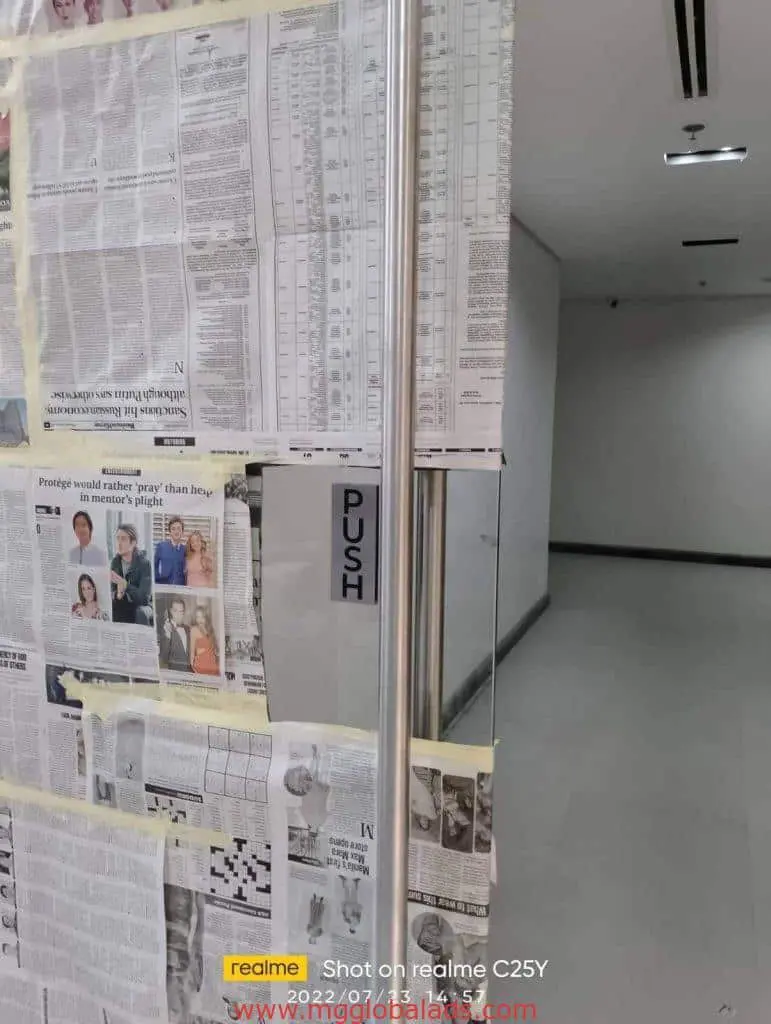 Acrylic PUSH door signage on glass with newspaper cover, visible clean hallway, Makati location by M&G Global Ads.