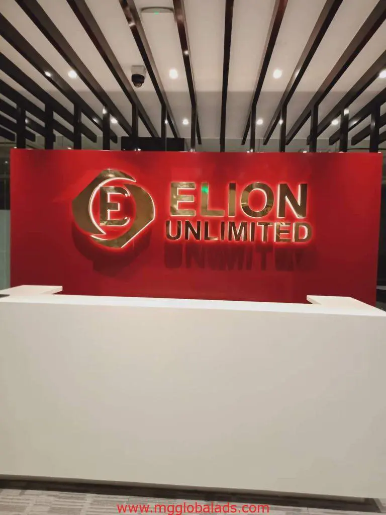 Illuminated metallic signage for ELION UNLIMITED in modern Makati office reception with red wall by M&G Global Ads.