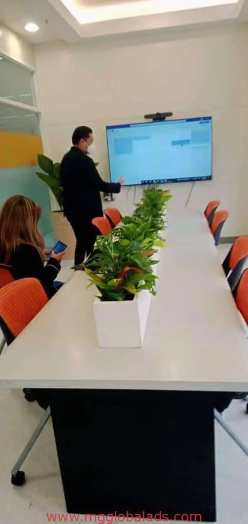 Indoor office signage at corporate client conference room in Makati, with large screen and orange chairs by M&G Global Ads.