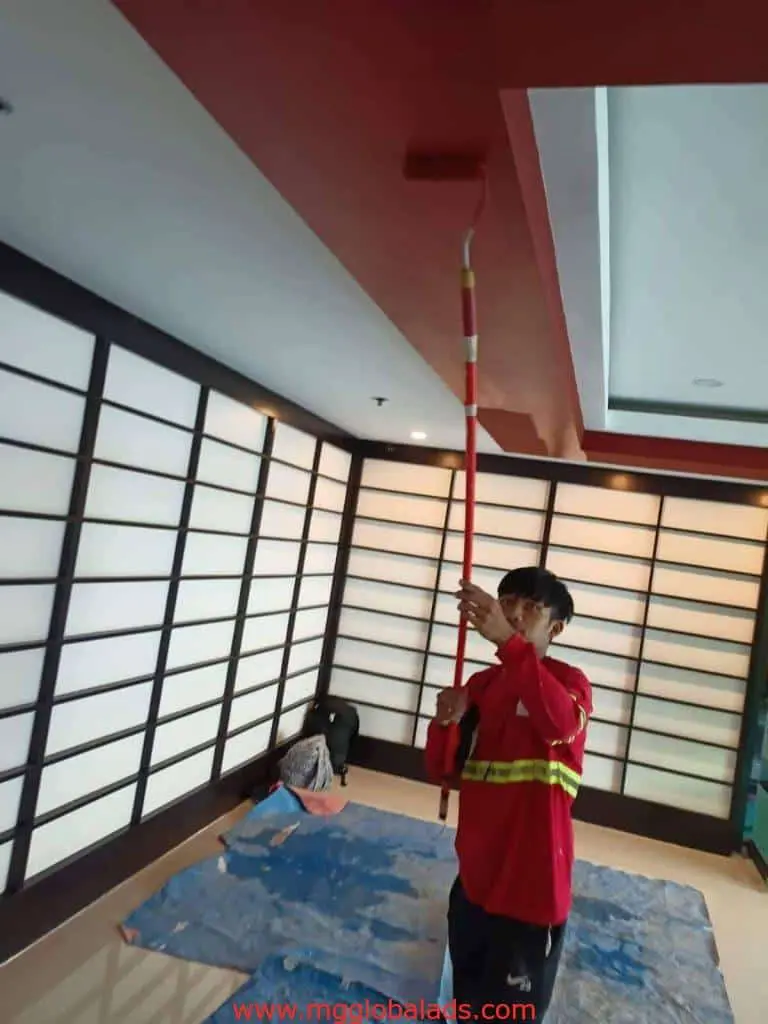 LED signage installation in a modern Ortigas room, with red ceiling painting in progress by M&G Global Ads.