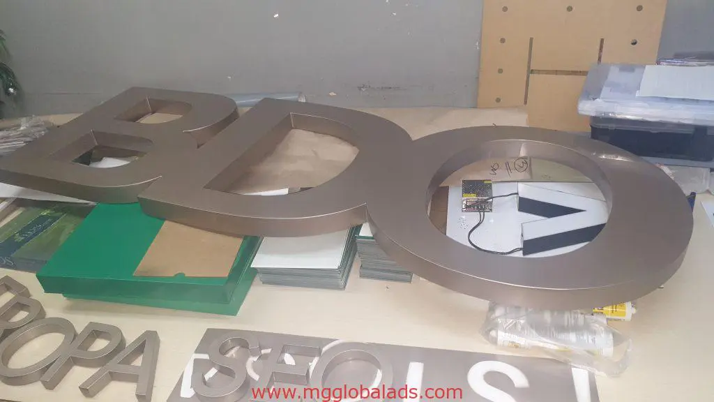 Indoor metallic cutout letter signage for BDO being crafted in a well-lit Makati workspace by M&G Global Ads.