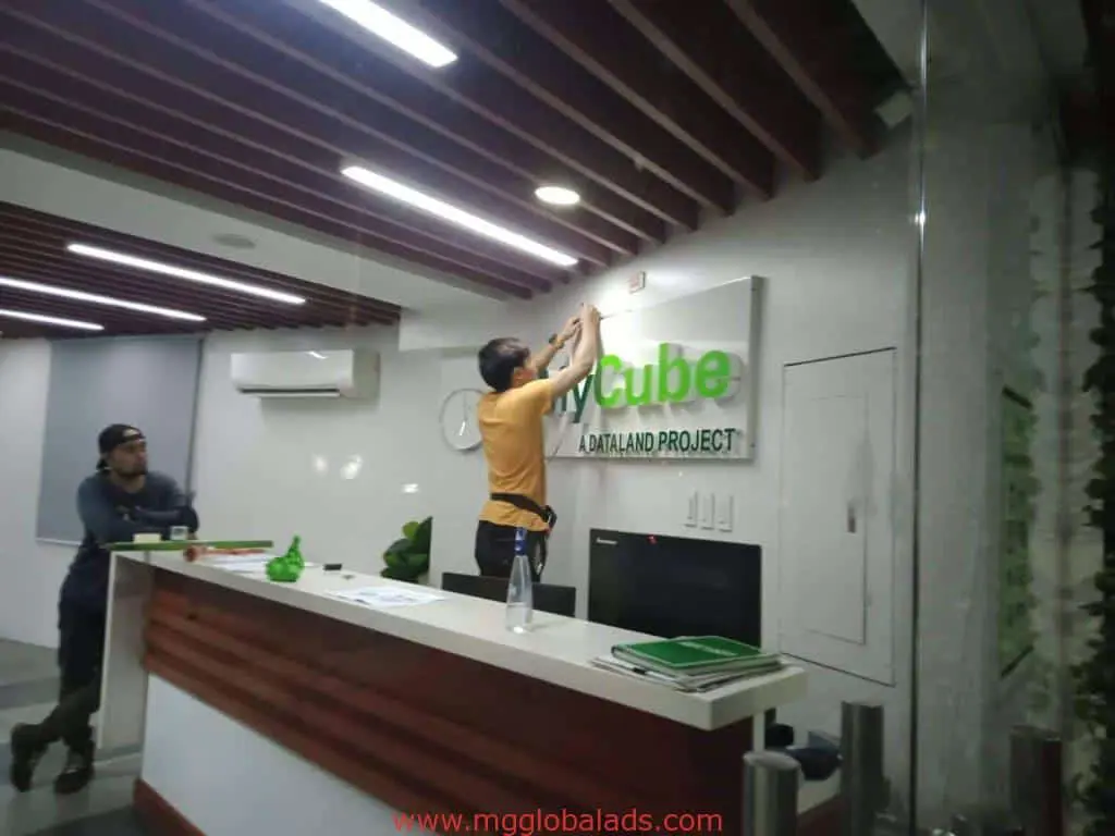 Installing acrylic signage for MyCube Datland Project in a modern Mandaluyong office by M&G Global Ads.