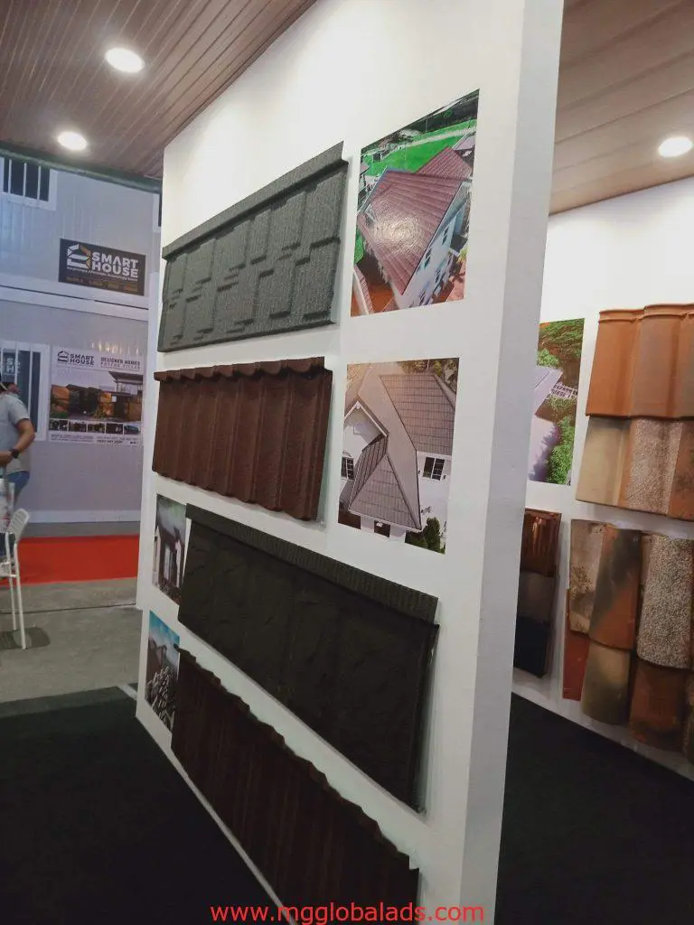Indoor signage display with roofing tile samples and house photos at exhibition in Quezon City by M&G Global Ads.
