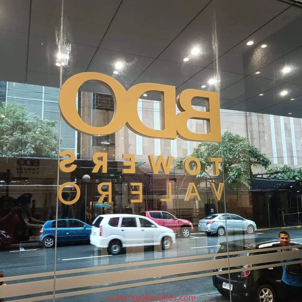 Reversed yellow building signage for BDO TOWERS VALERO, Makati, seen through glass window by M&G Global Ads.