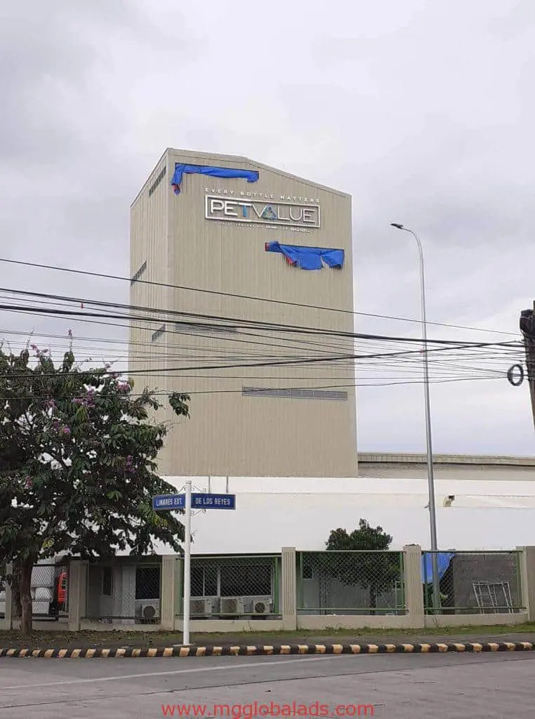 LED building signage for Pet Value on tall industrial building in Pasig, partly covered by blue tarps. by M&G Global Ads.