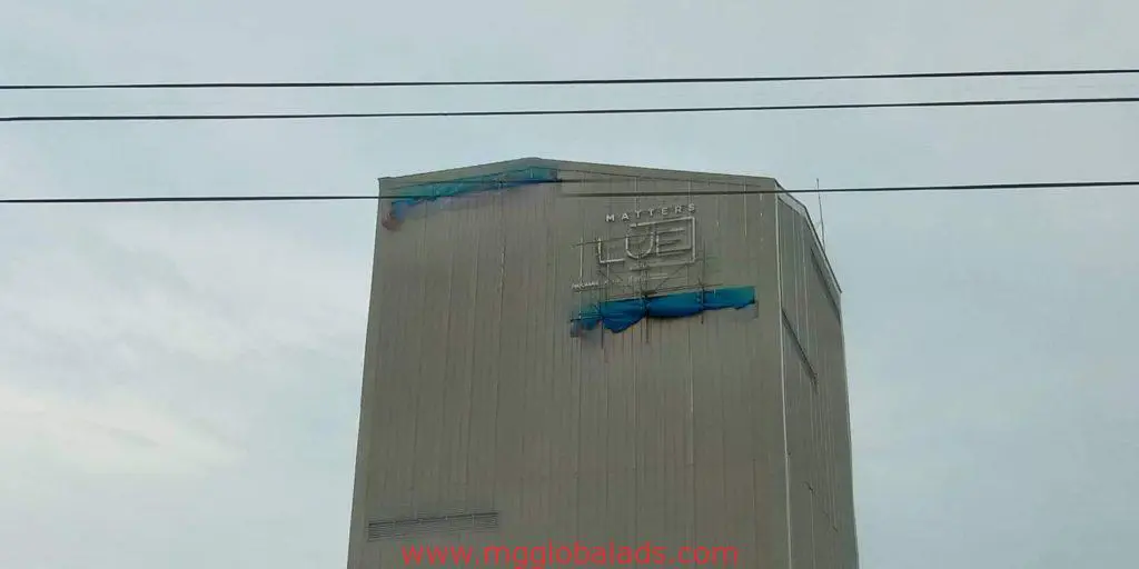 Industrial building signage for UTE and NAVIERES with blue tarps in Pasig, power lines above. Signage by M&G Global Ads.