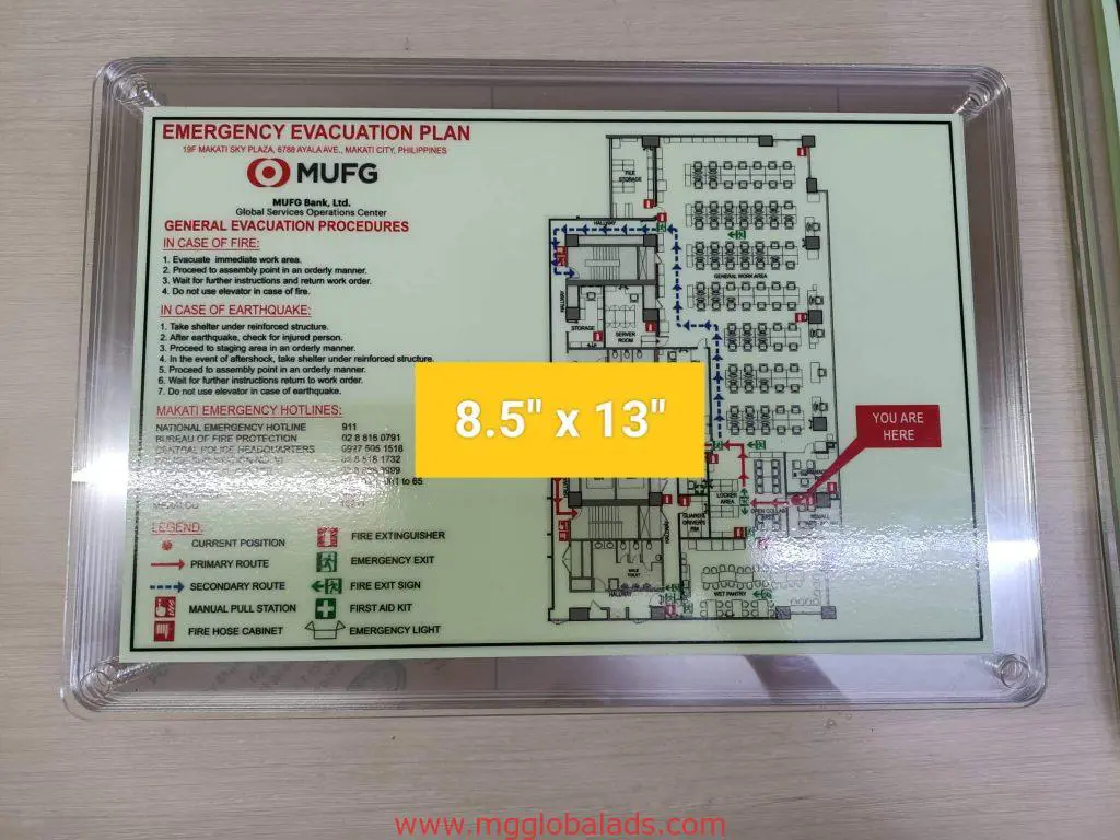 Emergency evacuation plan indoor signage in plastic case with floor layout and exits, shown in Makati by M&G Global Ads.