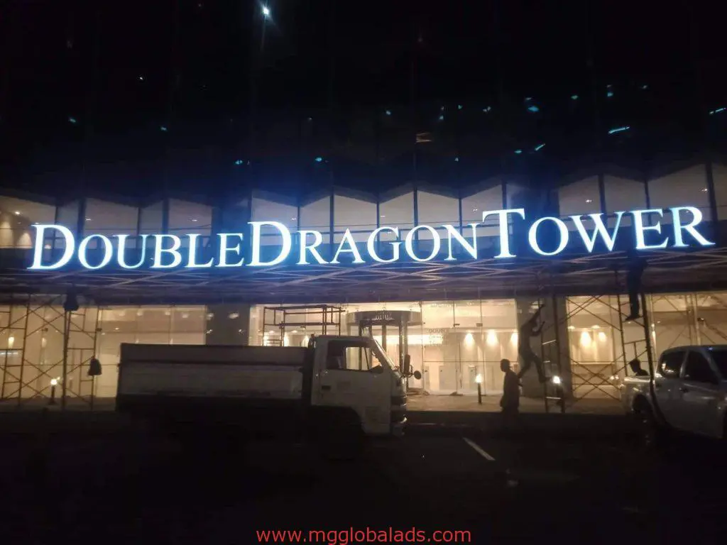 Outdoor LED building signage for DOUBLE DRAGON TOWER in Mandaluyong at night, with parking lot—by M&G Global Ads.