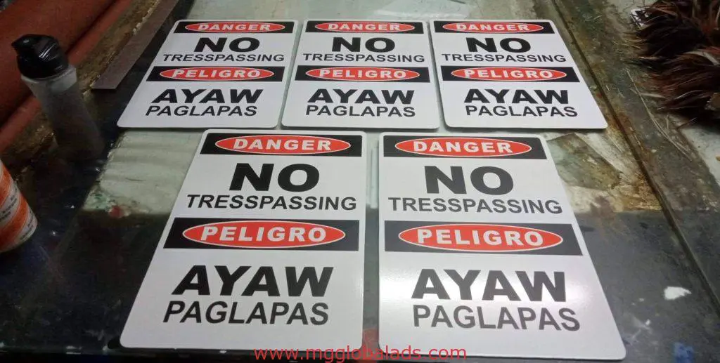 Outdoor Danger: No Trespassing safety signage in English, Spanish, Filipino on table in Makati by M&G Global Ads.