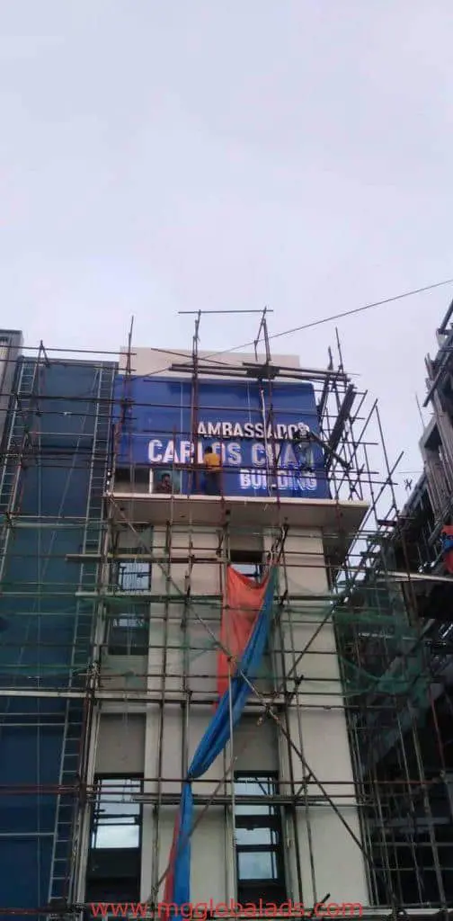 Metal signage for AMBASSADORS CARLOS CALO BUILDING on a construction site in Mandaluyong by M&G Global Ads.