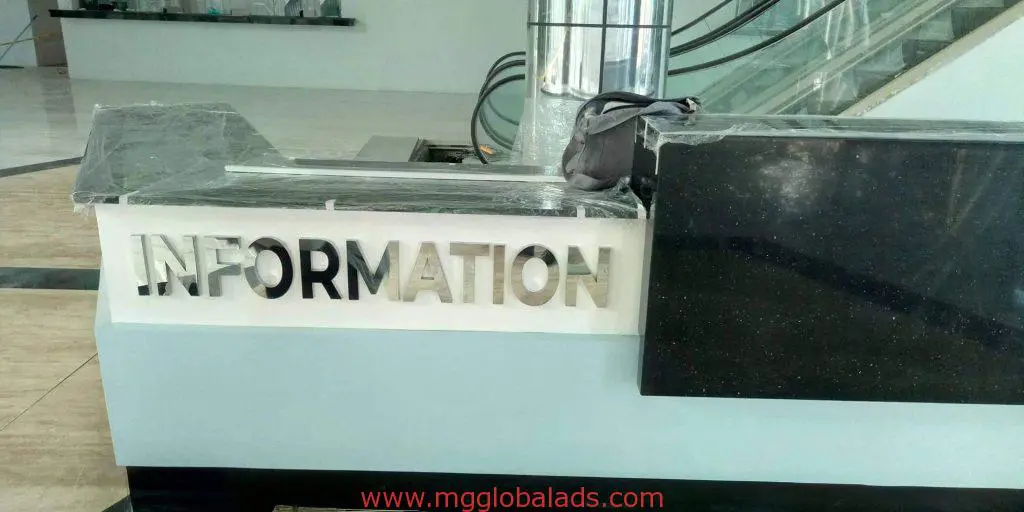 Partially covered acrylic indoor counter signage with plastic wrap near escalator in Makati mall by M&G Global Ads.