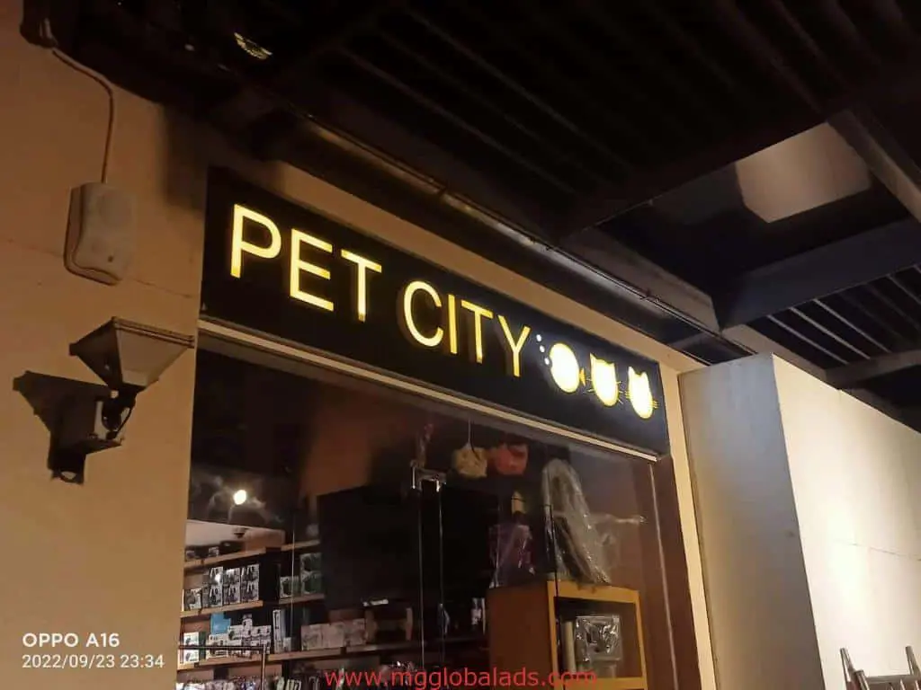 PET CITY illuminated LED signage with paw, cat, dog icons in Quezon City storefront by M&G Global Ads. Pet products in window.