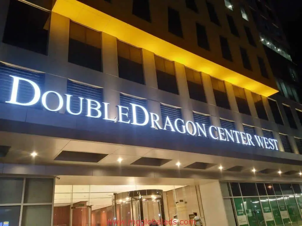 LED signage for DoubleDragon Center West on a modern building exterior at night in Ortigas by M&G Global Ads.