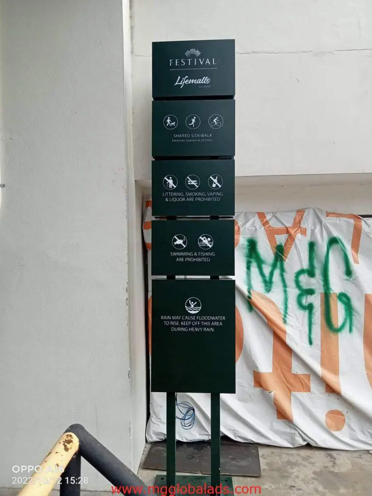 Festival Lifemalls building signage post in Makati listing rules and warnings, with a white wall behind, by M&G Global Ads.