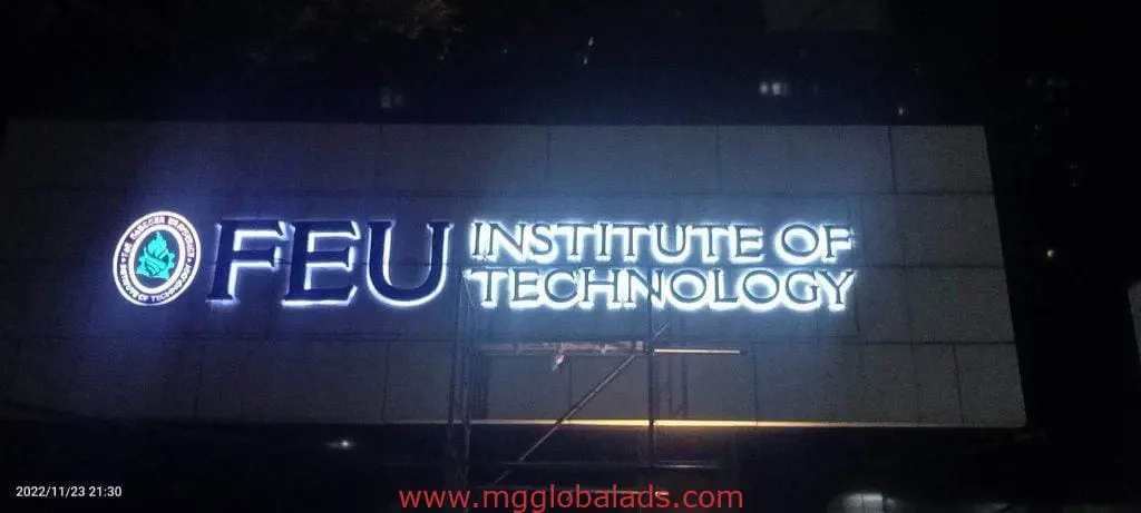 FEU Institute of Technology building metallic signage with logo, scaffold below, night view in Ortigas by M&G Global Ads.
