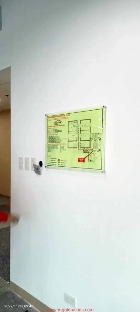 Emergency evacuation plan signage with indoor signs and security camera in Makati office, sleek wall switches by M&G Global Ads.