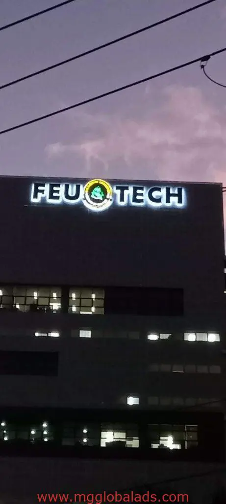 LED building signage for FEU TECH with green and yellow logo in Quezon City at dusk, by M&G Global Ads.