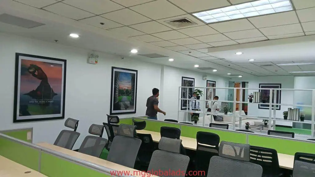 Modern office in Makati with LED signage, green and beige desks, black chairs, posters; by M&G Global Ads.