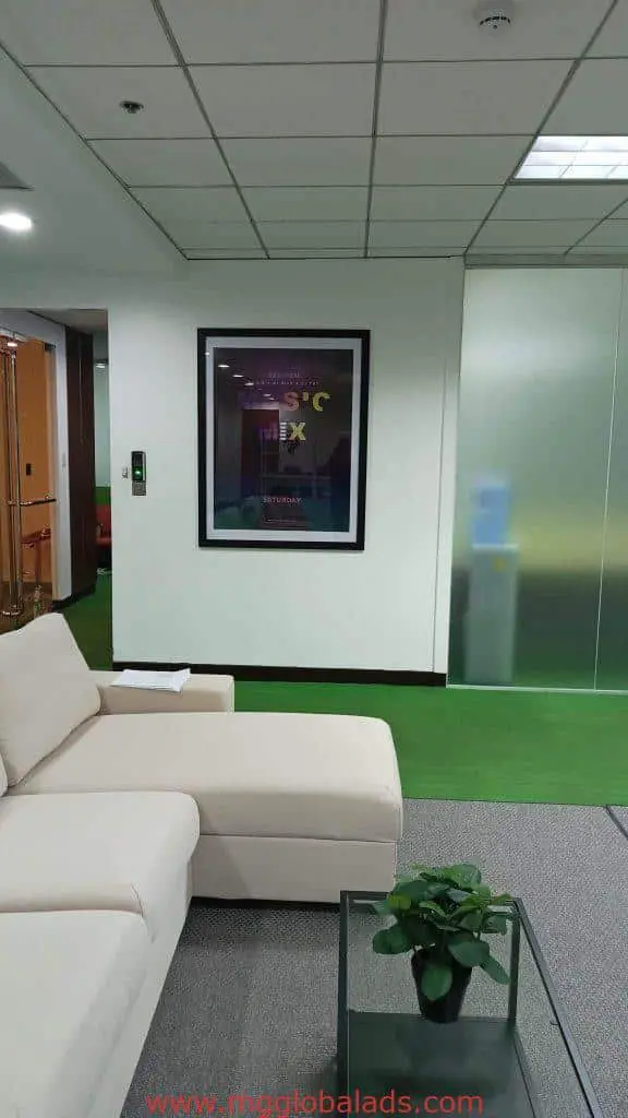 Sleek metallic office signage for client in BGC, modern lounge sofa, glass coffee table, potted plant by M&G Global Ads.