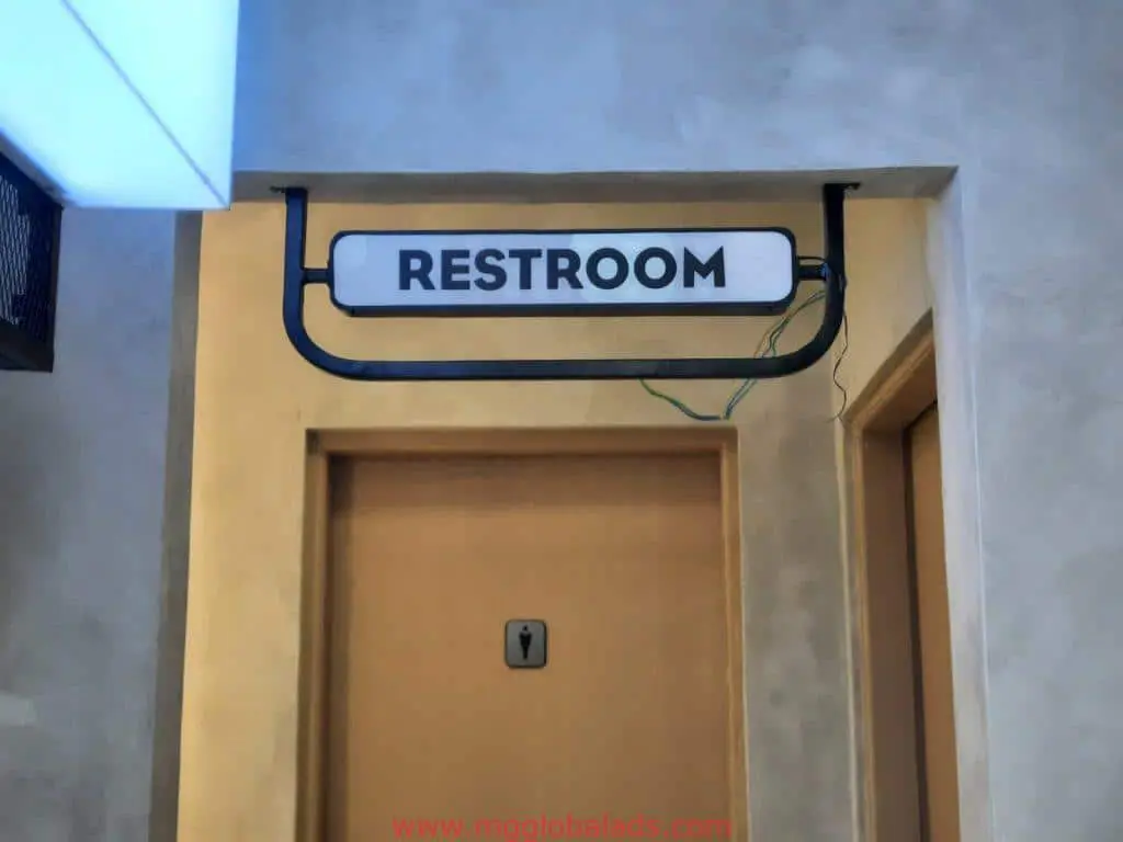 Restroom door metallic signage in a hallway, bold black letters, clear building sign, Quezon City by M&G Global Ads.