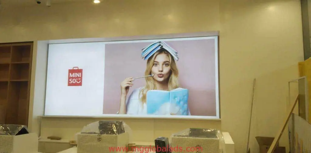 MINISO building signage display at Ortigas store with logo, thoughtful woman photo, and pink background by M&G Global Ads.
