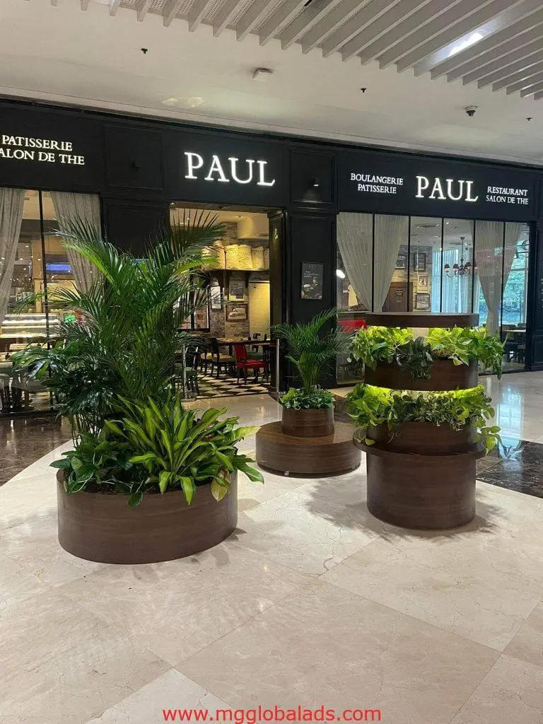 PAUL restaurant outdoor signage in elegant white lettering at Makati entrance with planters, by M&G Global Ads.