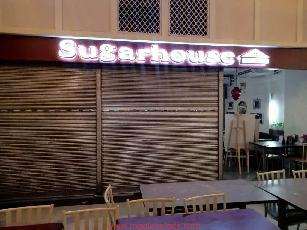 Illuminated building signage for Sugarhouse, metal shutters down, closed store in BGC by M&G Global Ads.