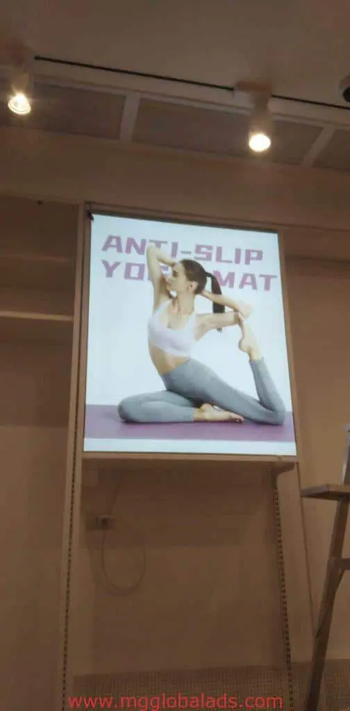 Modern indoor poster signage for anti-slip yoga mat ad in Makati; athletic woman poses on mat; by M&G Global Ads.