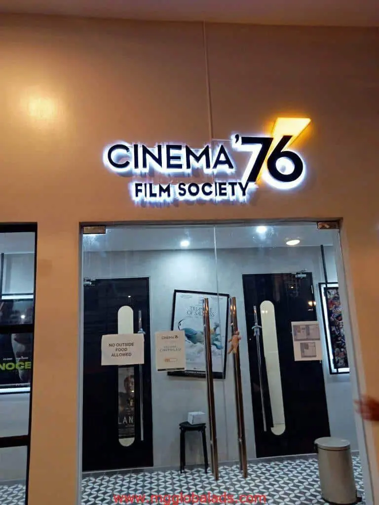 LED signage for Cinema 76 Film Society above glass doors in Quezon City, with posters inside. by M&G Global Ads.