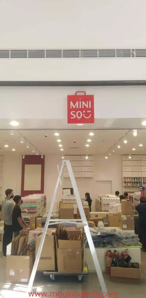 MINISO LED signage installation in Makati, red MINISO logo and supplies visible during store setup by M&G Global Ads.
