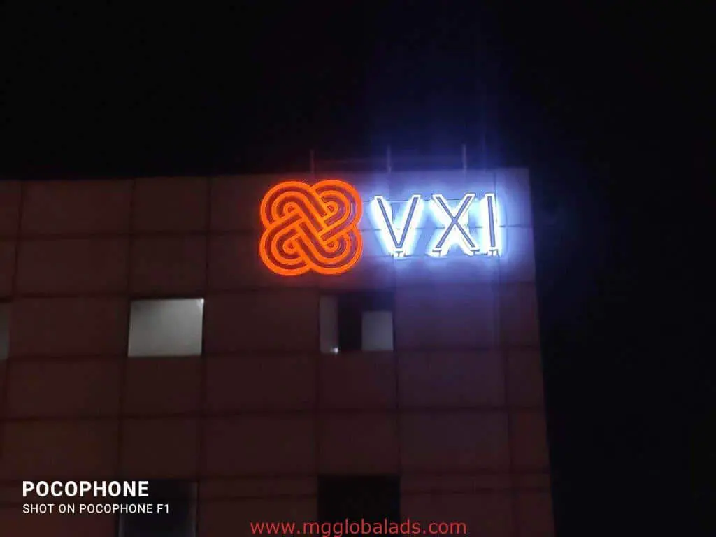 VXI LED signage with red-orange logo and white letters on a building at night in Ortigas by M&G Global Ads.